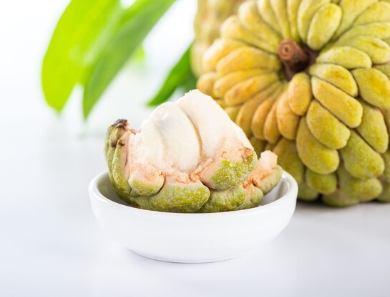 Spiky durian fruit split open to reveal its creamy yellow flesh